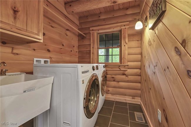 Laundry room with utility sink, tile floor, front load washer / dryer | Image 11