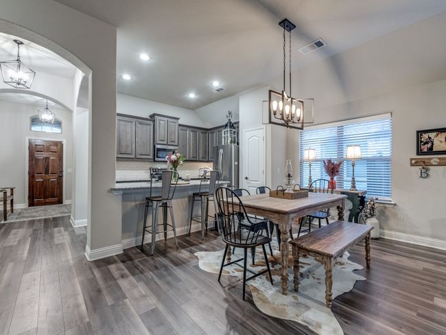 Dining room with dark wood-type flooring and a notable chandelier | Image 11