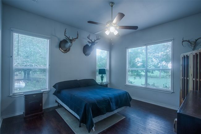 Bedroom featuring multiple windows, dark wood-style floors, and ceiling fan | Image 20