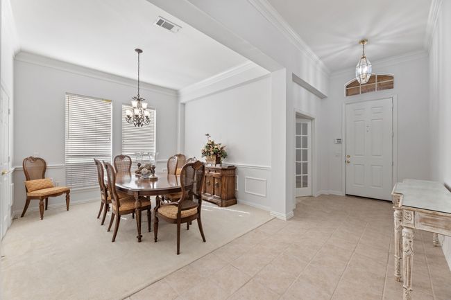 Carpeted dining room featuring ornamental molding and a notable chandelier | Image 9