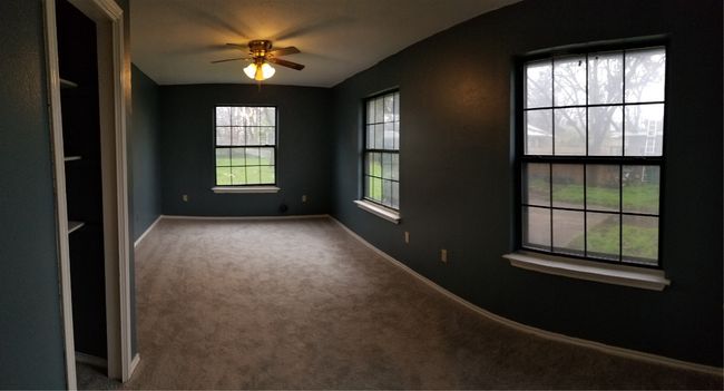 Empty room with carpet flooring, a ceiling fan, and baseboards | Image 13