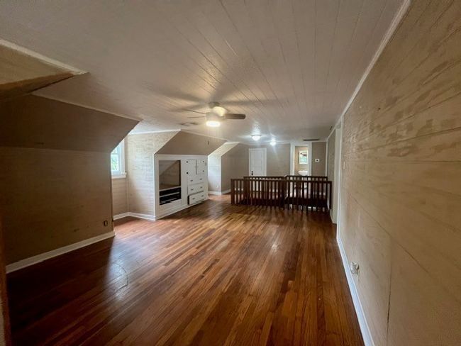 Bonus room featuring wood-type flooring, ceiling fan, wood walls, wood ceiling, and lofted ceiling | Image 26