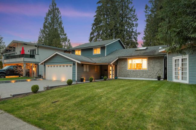 View of front of home with french doors, stone siding, a garage, a yard, and a shingled roof | Image 5
