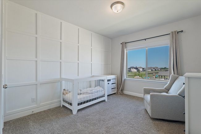 Carpeted bedroom with baseboards and a crib | Image 32