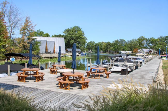 You have a large patio area on the water. There are 4 Octagon Picnic tables with umbrellas. There is fire pit for all the residents enjoy with Family and friends | Image 20