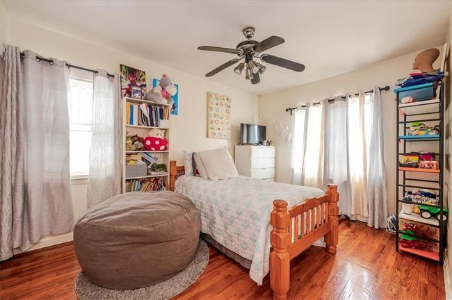 Bedroom featuring hardwood / wood-style flooring, multiple windows, and ceiling fan | Image 9