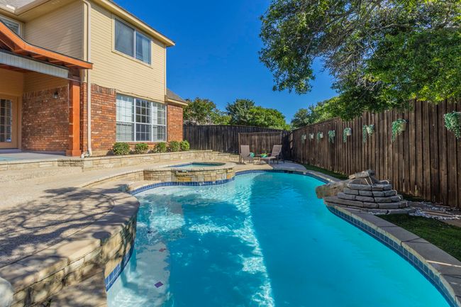 View of pool featuring a patio, a fenced backyard, and a pool with connected hot tub | Image 34