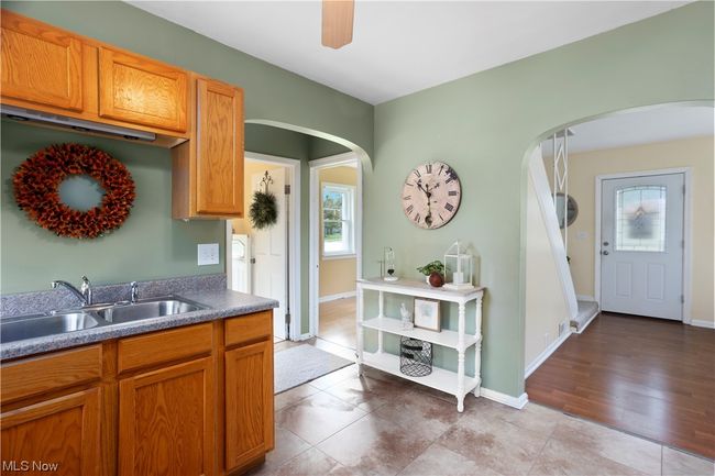 Kitchen with brown cabinets and light tile flooring | Image 5