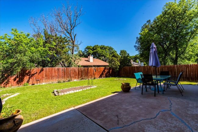 View of yard with patio and fenced backyard. | Image 22
