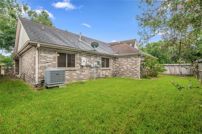 Rear elevation with full brick finish, grassy yard, and space for landscaping or play. | Image 25