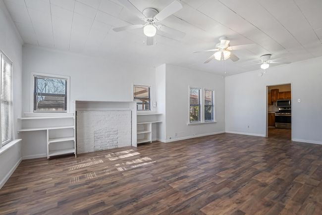 Unfurnished living room featuring ceiling fan and dark hardwood / wood-style flooring | Image 4