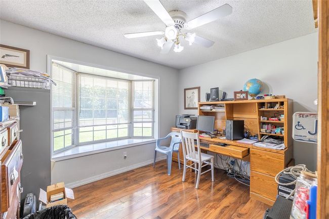 Home office with plenty of natural light, wood finished floors, ceiling fan, a textured ceiling, and baseboards | Image 22