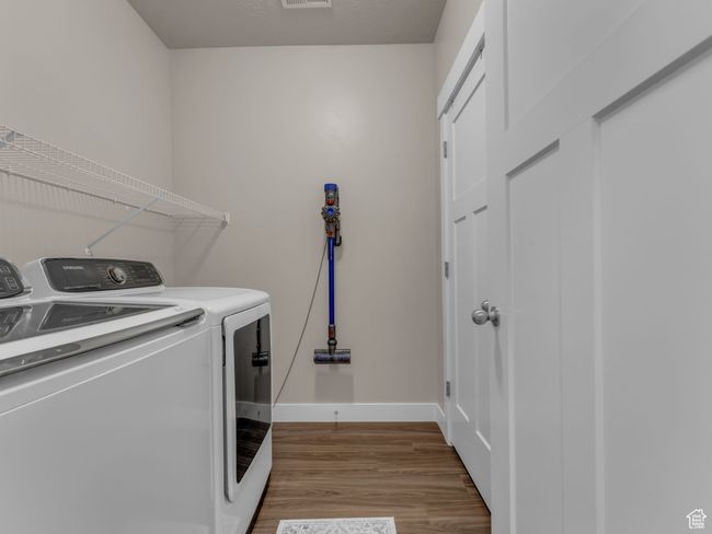 Laundry area with washing machine and dryer, wood finished floors, and baseboards | Image 14