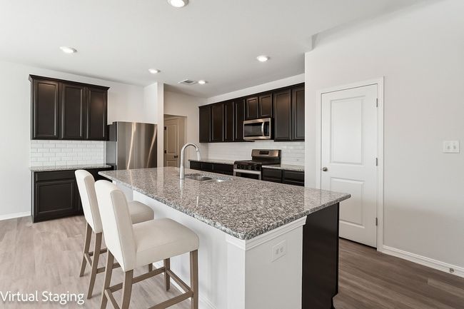 Kitchen with stainless steel appliances, a sink, baseboards, light wood finished floors, and backsplash | Image 7