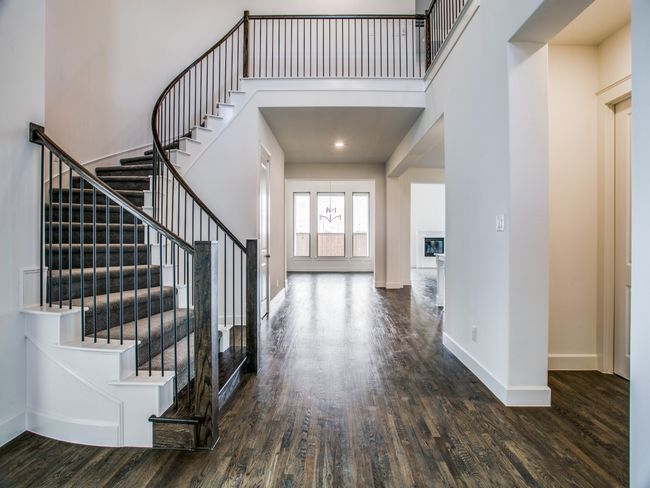 Entryway with wood finished floors, a high ceiling, and stairway | Image 5