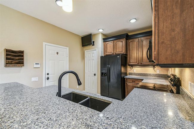 The kitchen boasts 42-inch cabinets with elegant crown molding granite countertops. | Image 11