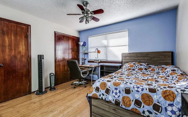 Bedroom with light wood-style floors, a textured ceiling, ceiling fan, and multiple closets | Image 14