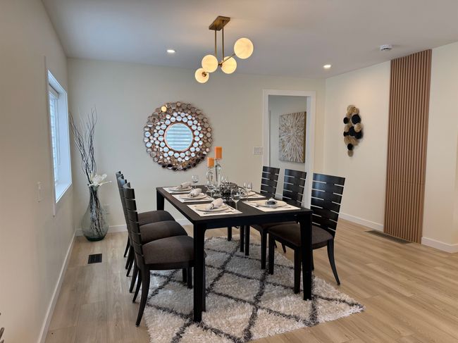 Dining area with light wood finished floors, recessed lighting, and a chandelier | Image 26
