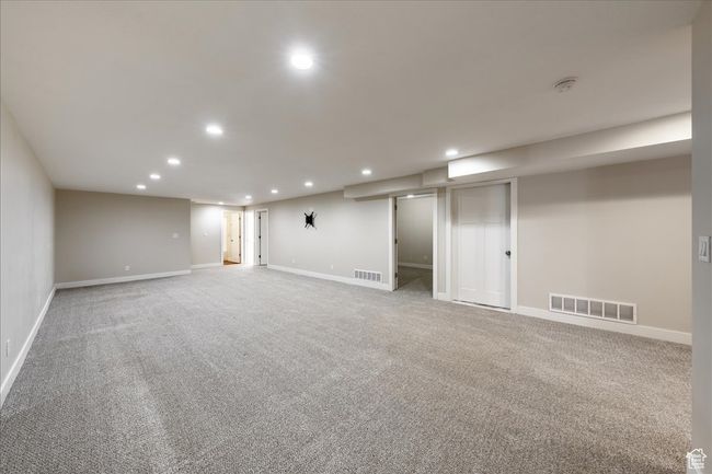 Finished basement featuring baseboards, carpet floors, visible vents, and recessed lighting | Image 40