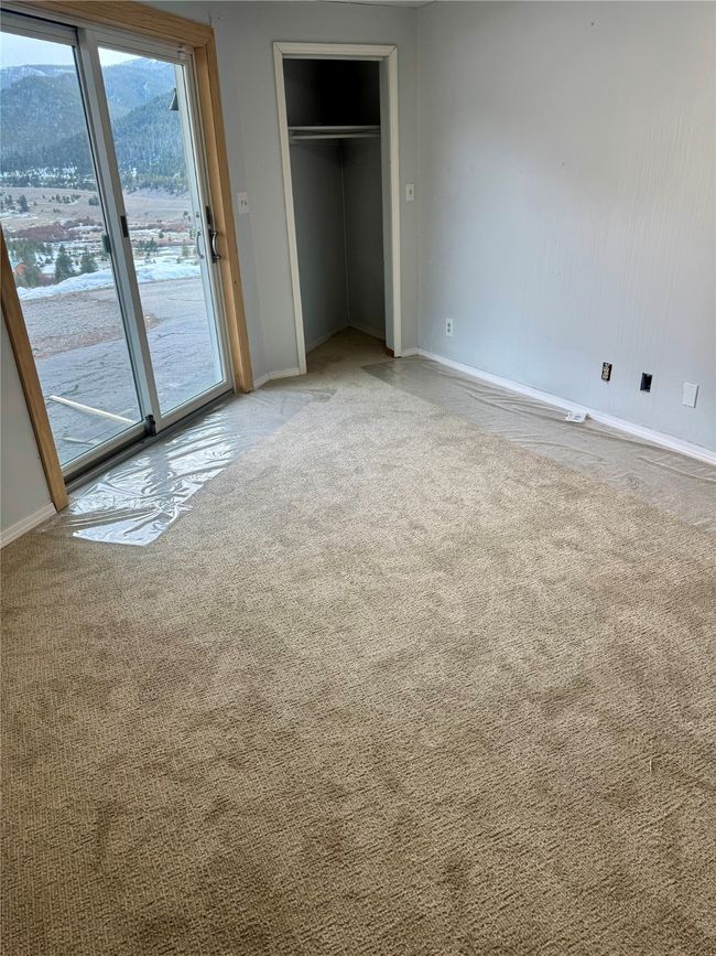 Unfurnished bedroom featuring baseboards, a closet, carpet, and access to outside | Image 63