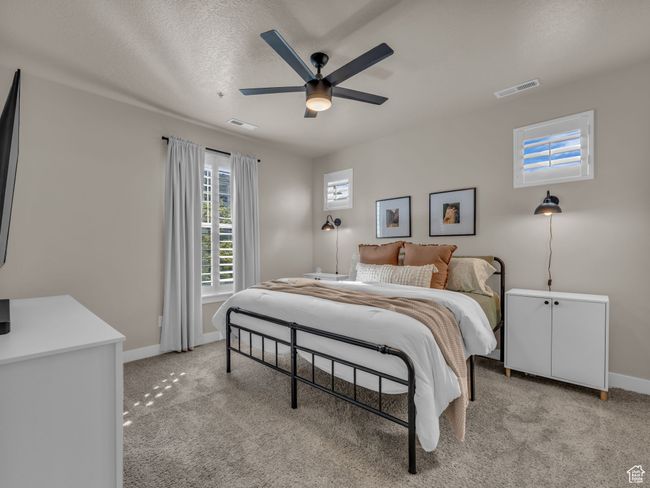 Bedroom featuring baseboards, light colored carpet, and ceiling fan | Image 8