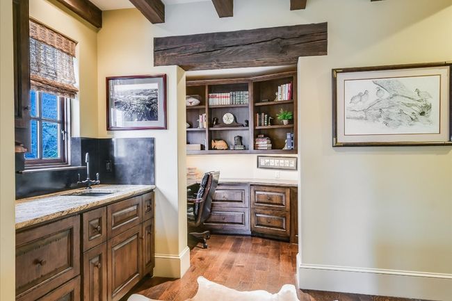 Office featuring beamed ceiling, baseboards, built in desk, wood finished floors, and a sink | Image 36