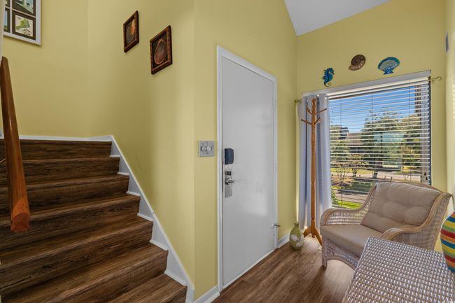Foyer entrance featuring stairs, lofted ceiling, wood finished floors, and baseboards | Image 7