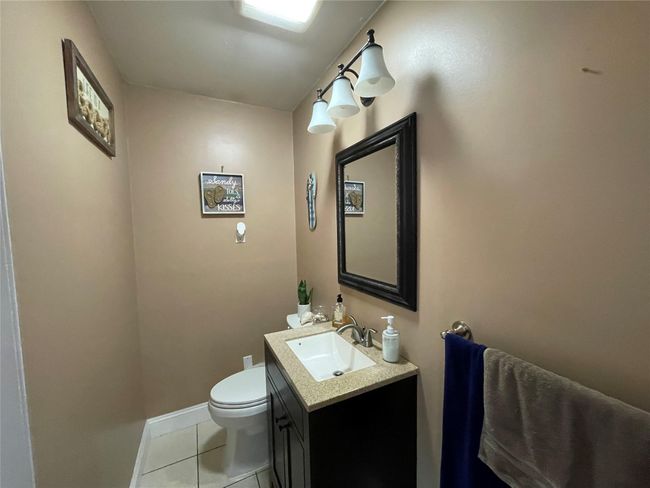 Half bathroom featuring vanity, tile patterned floors, toilet, and baseboards | Image 27