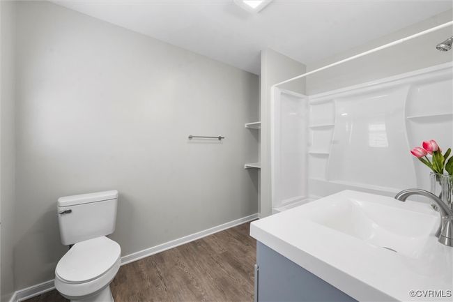 Bathroom featuring baseboards, wood finished floors, toilet, and a shower | Image 19