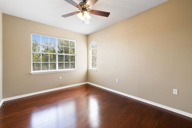 Empty room with baseboards, dark wood finished floors, and a ceiling fan | Image 27