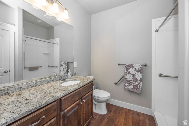 Bathroom featuring vanity, toilet, hardwood / wood-style floors, and walk in shower | Image 10