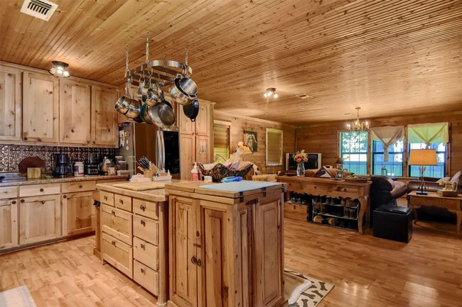 Kitchen with open floor plan, light countertops, visible vents, freestanding refrigerator, and light brown cabinets | Image 20