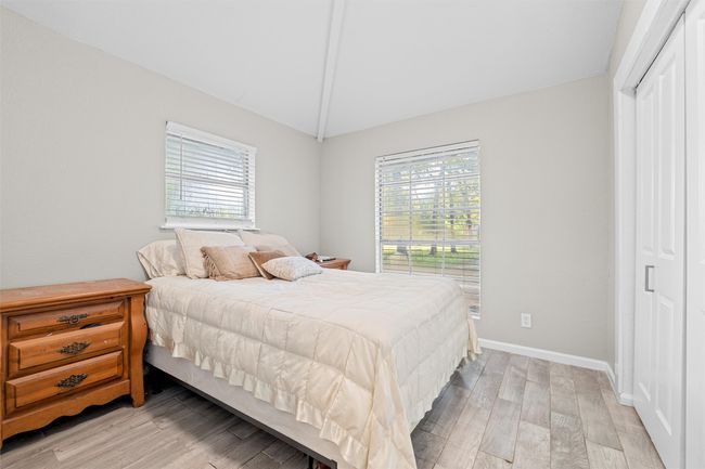 Bedroom with multiple windows, lofted ceiling, and light wood finished floors | Image 22