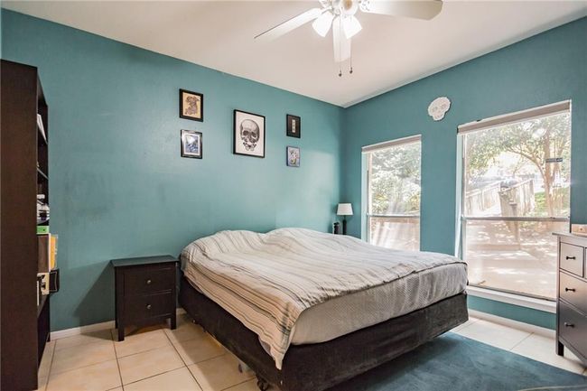 Bedroom featuring light tile patterned flooring, a ceiling fan, and baseboards | Image 13
