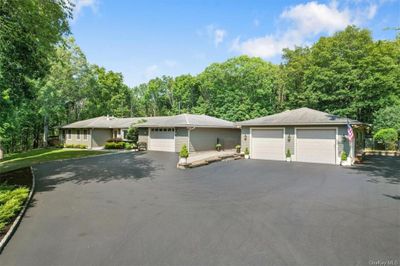 Ranch-style home featuring beautiful, landscaped yard and privacy | Image 1