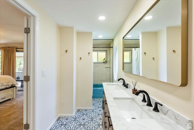 Bathroom with plenty of natural light, double vanity, recessed lighting, connected bathroom, and curtained shower | Image 37