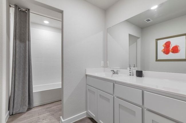 Bathroom featuring shower / tub combo, vanity, and tile flooring | Image 21