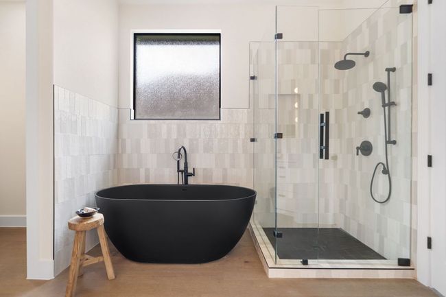 The spa-inspired primary bathroom features a freestanding tub and a separate walk-in shower, ideal for relaxing in peace after a long day. | Image 17