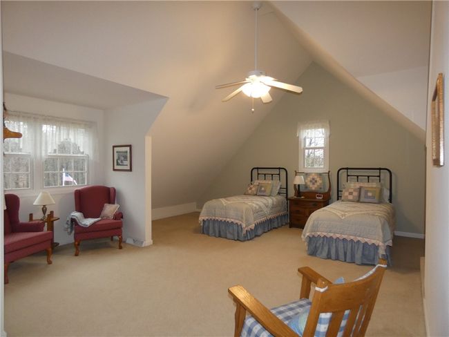 Bedroom features both a seating area and ample closet space for your guests | Image 33