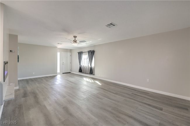 Spare room featuring ceiling fan, wood finished floors, visible vents, and baseboards | Image 8