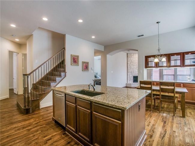 Kitchen featuring a sink, dark wood-style flooring, stainless steel dishwasher, recessed lighting, and light stone countertops | Image 8