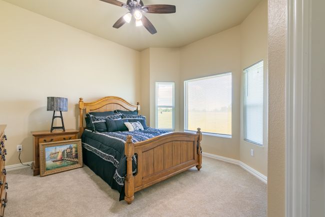 Bedroom with light carpet, multiple windows, and ceiling fan | Image 11