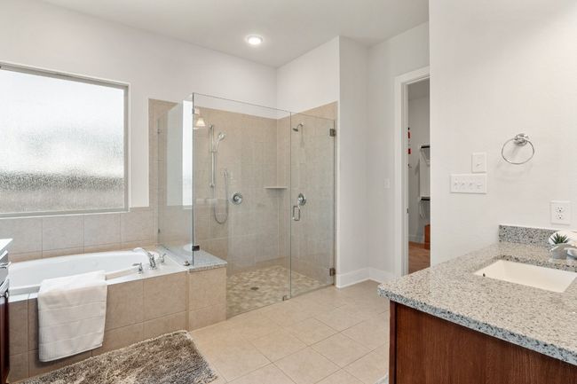 Full bath featuring a garden tub, vanity, tile patterned flooring, and a shower stall | Image 17
