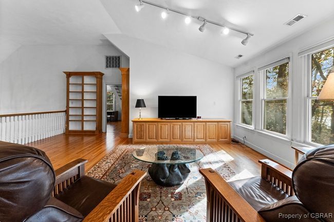 Living room featuring lofted ceiling, light wood-style floors, and rail lighting | Image 37