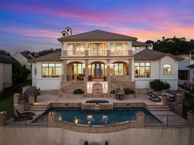 Rear view of house with a balcony, stairway, stucco siding, a pool with connected hot tub, and a patio | Image 30