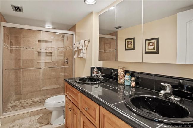 Tiled walk in shower with double sinks on granite countertops | Image 20