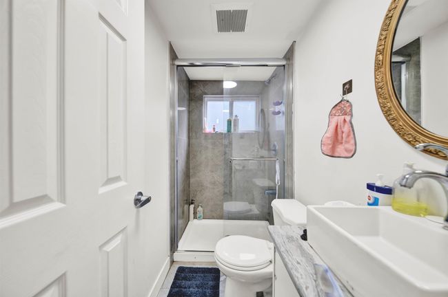 Full bath featuring toilet, a stall shower, vanity, and baseboards | Image 11