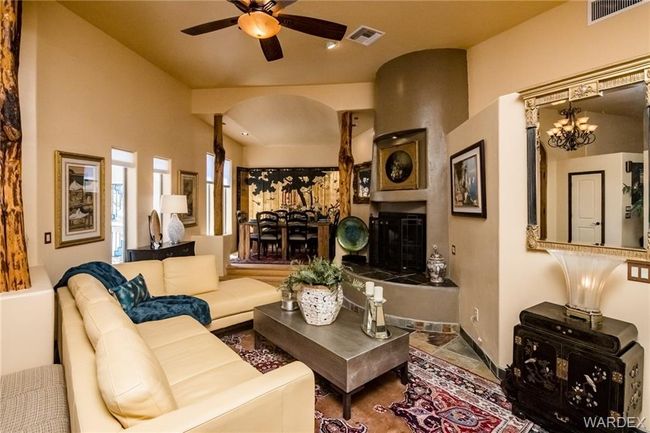 Living area featuring arched walkways, ceiling fan, and a chandelier | Image 44