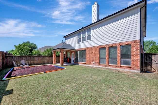 Outside, enjoy shade under the covered patio or roam in this yard | Image 38