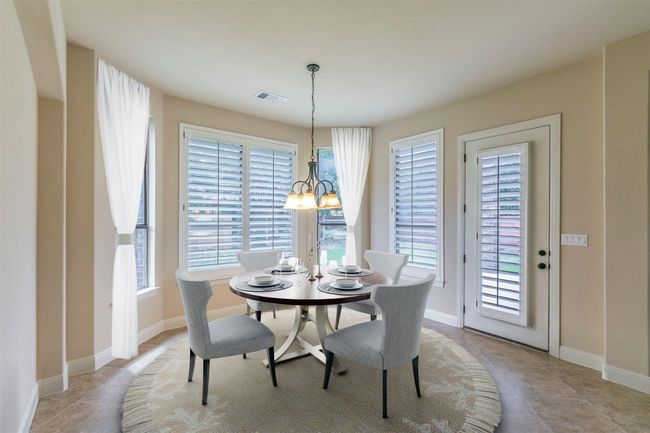 Dining area featuring baseboards, visible vents, a chandelier, and light tile patterned floors | Image 12